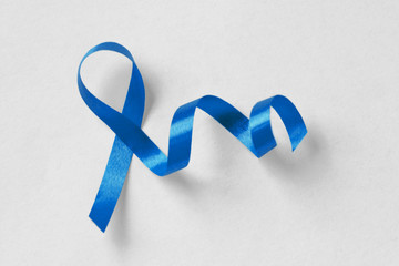 Blue ribbon on white background - Concept of prostate cancer awareness