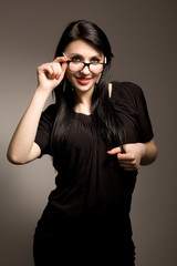 Young brunette woman in black clothing and glasses