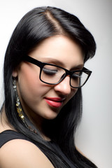 Young brunette womans face with extended lashes in glasses