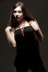 Young brunette woman in black casual clothing and massive accessories
