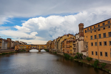 The Ponte Vecchio, a medieval stone closed-spandrel segmental arch bridge over the Arno River, in Florence, Italy, noted for still having shops built along it.  