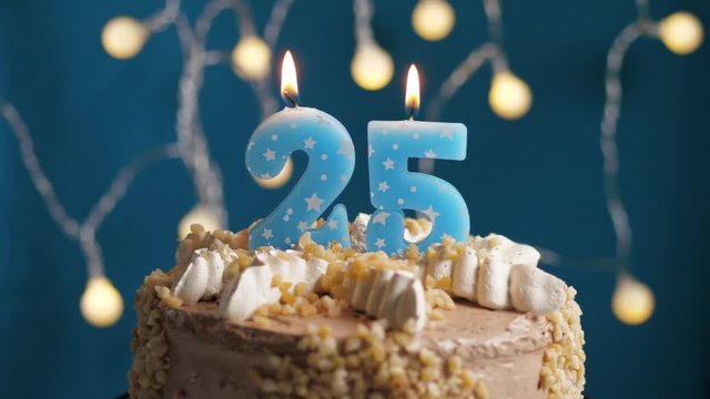 Birthday cake with 25 number candle on blue backgraund. Candles blow out. Slow motion and close-up view