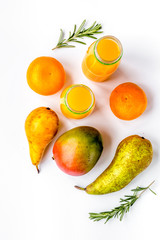 bottles of smoothie with fruits on white table top view