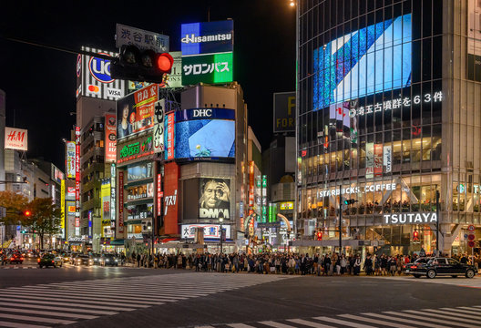 TOKYO, JAPAN - NOVEMBER 15, 2019 : Pedestrians cross at Shibuya Crossing  in Tokyo, Japan. ( Focus on mobile phone,)  Shibuya Crossing is one of the busiest crosswalks in the world.