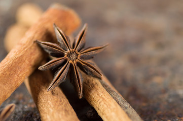 Cinnamon sticks, anise stars and black peppercorns on textured background