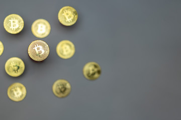 Golden bitcoins on grey background with copy space on right side. Crypto currency concept photo.