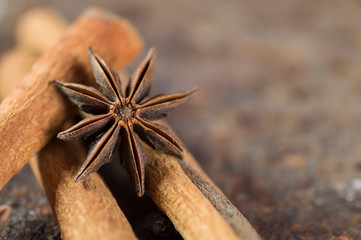 Cinnamon sticks, anise stars and black peppercorns on textured background