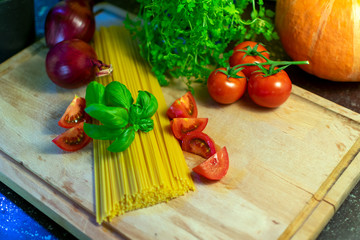rohe Spaghetti mit dekorationen aus Tomaten, Zwiebeln und Basilikum