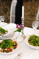 Festive table setting and snacks on the Banquet table. Purple Alstroemeria in a white vase