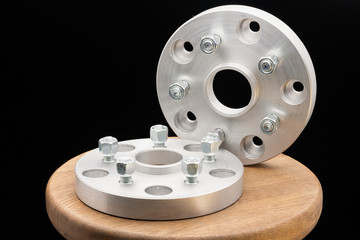 Automotive parts - close up new stainless metal remote adapter spacer wheel hub of the car on black...
