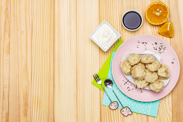 Fish dumplings. The concept of healthy food for children. Sour cream, soy sauce, cutlery. Wood background