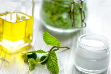 organic cosmetics with herbal extracts of mint on wooden background