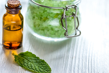 organic cosmetics with herbal extracts of mint on wooden background