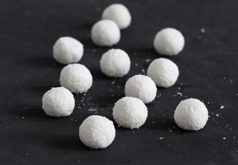 Dessert curd balls in coconut shavings on a dark gray background