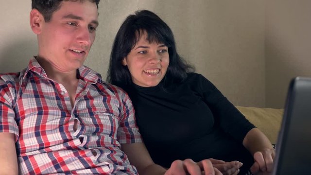Discussing Happy Couple. Woman Points Finger On Laptop Screen Talking To Man. Surfing Intrenet Sitting On Sofa Couch. Slow Motion 30p 0.5 Real Time Speed 60p