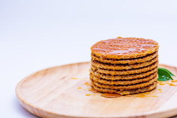 Wafer sprinkled with honey on wooden tray ready to serve.