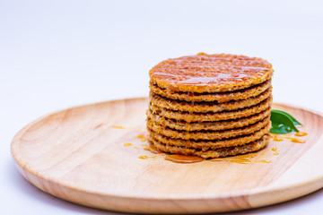 Wafer sprinkled with honey on wooden tray ready to serve.