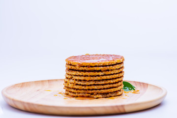 Wafer sprinkled with honey on wooden tray ready to serve.