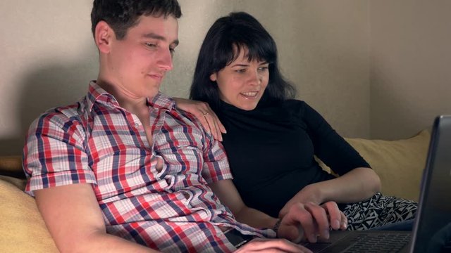 Woman Asks Man To Buy Something For Her Online. Surfing Intrenet Sitting On Sofa Couch. Slow Motion 30p 0.5 Real Time Speed 60p