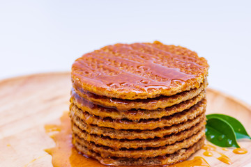 Wafer sprinkled with honey on wooden tray ready to serve.