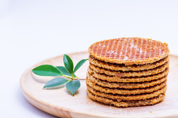 Wafer sprinkled with powder on wooden tray ready to serve.