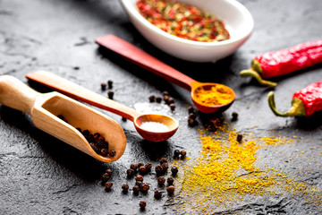 spices in wooden spoon on dark background