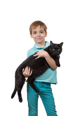 Caucasian child holds a large fluffy black pet cat. A boy in a blue T-shirt and jeans on a white isolated background. The child smiles, the cat is relaxed and happy. Copyspace.