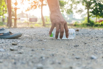Men hand is picking up plastic on ground dry leaves in autumn. Of December, Concept of save the earth