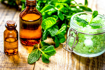 organic cosmetics with herbal extracts of mint on wooden background