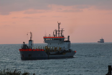 Obraz premium ship in the sea at sunset
