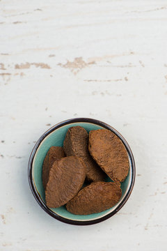 Brazil Nuts In A Turquoise Bowl On A White Shabby Background