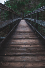 Fototapeta na wymiar Moody empty bridge leading into a dark forest in Tallulah Falls Georgia