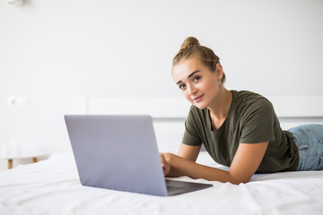 Portrait of a relaxed young woman using laptop in bed at home