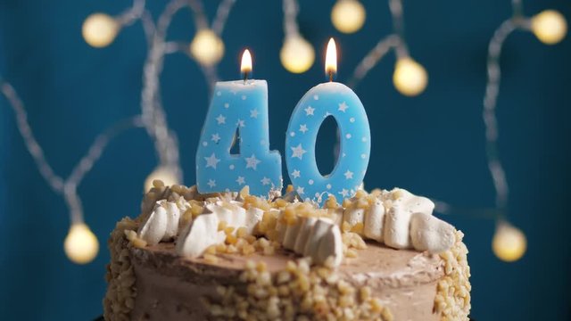 Birthday cake with 40 number candle on blue backgraund. Candles blow out. Slow motion and close-up view