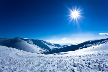 Landscape of snow winter valley surrounded by hills on sunny day