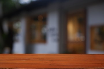 wood table in front of blurred cafe exterior