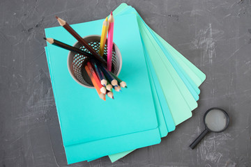 colored pencils on school notebooks on a cement table, top view, back to school