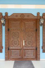 Wooden to the door with the carved pattern.