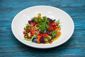 Escabeche fish dish with caviar: mackerel in marinade with vegetable, on a plate on the wooden blue background.