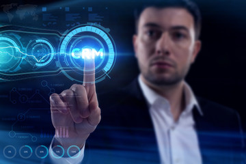 Business, Technology, Internet and network concept. Young businessman working on a virtual screen of the future and sees the inscription: CRM