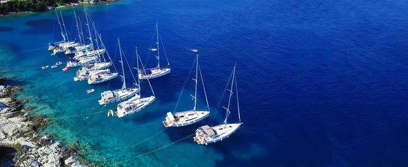 Fotobehang Luchtfoto drone ultra brede foto van zeilboten aangemeerd in de paradijselijke baai van Fiskardo, Kefalonia-eiland, Ionisch, Griekenland © aerial-drone