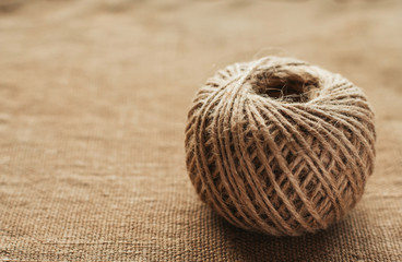 Reel of jute twine on a background of old burlap copy space. Needlework rope.