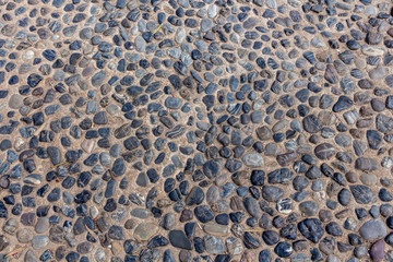 Beautiful texture of path of gray smooth stones on the orange background is in the park