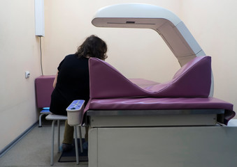 A woman undergoes a study - bone densitometry of the hands. Detects a decrease in bone density in the early stages. Osteoporosis Test