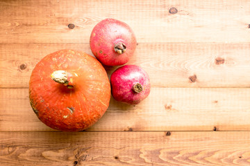 &nbsp; pumpkin and pomegranates lie on a wooden natural background