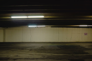 Down in the old dirty and empty parking garage under the city streets. 