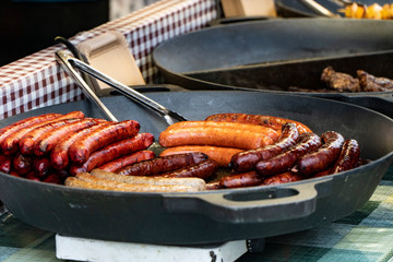 Prague, Czech Republic 2019:Traditional hot dog preparation on coal fire on the street during the Christmas market