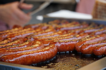 Prague, Czech Republic 2019:Traditional hot dog preparation on coal fire on the street during the Christmas market