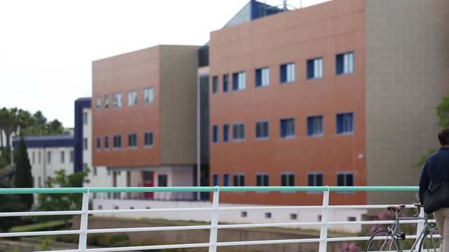 Hombre paseando con bicicleta entre edificios de oficinas
