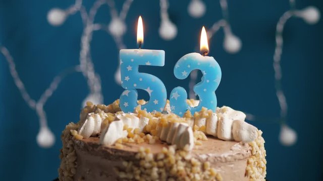 Birthday cake with 53 number candle on blue backgraund. Candles blow out. Slow motion and close-up view